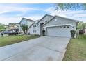 Suburban single-Gathering home showcasing a two-car garage, well-kept lawn and driveway with parking at 2122 Korat Ln, Maitland, FL 32751