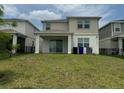 Backyard view featuring a spacious lawn and a view of neighboring homes, perfect for outdoor activities at 2620 Blowing Breeze Ave, Kissimmee, FL 34744
