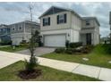 Two-story home features a two-car garage, manicured lawn, and a welcoming facade at 2620 Blowing Breeze Ave, Kissimmee, FL 34744