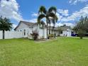 View of the home's exterior showcasing the meticulously landscaped yard with a vibrant palm tree at 2673 Dixie Ln, Kissimmee, FL 34744
