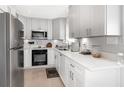Modern kitchen featuring white cabinetry, stainless steel appliances, quartz countertops, and ample storage space at 3104 Harrison Ave # E-30, Orlando, FL 32804