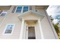 Exterior view of a townhome with neutral siding and a covered front porch at 3238 Wish Ave, Kissimmee, FL 34747