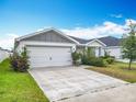 Charming one-story home features a two-car garage, manicured lawn, and well-maintained landscaping at 408 Lily Ln, Davenport, FL 33837