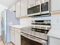 This kitchen features stainless steel appliances, including a stove, microwave, and refrigerator at 408 Lily Ln, Davenport, FL 33837