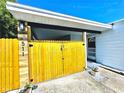 Charming home featuring a private, gated front entry and vibrant yellow wood fence with an inviting walkway to the front door at 511 S Alder Ave, Orlando, FL 32807