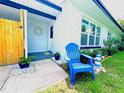 Charming home exterior features a blue Adirondack chair, white siding, and lush landscaping at 511 S Alder Ave, Orlando, FL 32807