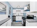 Modern kitchen with white cabinets, granite countertops, and stainless steel appliances for a sleek and stylish look at 511 S Alder Ave, Orlando, FL 32807
