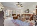 Comfortable living room featuring neutral carpet, ceiling fan, and access to the screened patio at 682 Lexington Dr, Clermont, FL 34711