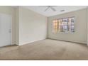 Bright living room featuring neutral walls, plush carpeting, a ceiling fan, and large windows for natural light at 8213 Claire Ann Dr # 108, Orlando, FL 32825