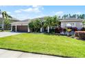 Charming single-story home with a three-car garage, lush landscaping, and a well-manicured lawn at 9126 Shadowbrook Trl, Orlando, FL 32825