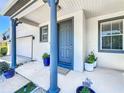 Inviting front entrance with a blue door, potted plants, and stylish trim at 1225 Greenley Ave, Groveland, FL 34736