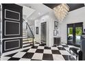Elegant foyer features black-and-white checkered floors, a dazzling chandelier, and grand staircase at 1581 Forest Ave, Winter Park, FL 32789