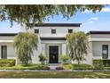 Striking modern home featuring manicured landscaping, mature trees, and a covered front entrance at 1581 Forest Ave, Winter Park, FL 32789