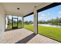 Covered patio with brick pavers overlooking a beautiful pond and manicured lawn at 10002 Brown Burrow St, Orlando, FL 32829