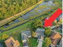 Expansive aerial shot showcases the home's tranquil setting by a waterway and the backyard swimming pool at 1027 Dees Dr, Oviedo, FL 32765
