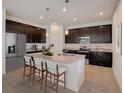 Kitchen with a large center island, stainless steel appliances, and dark cabinets at 12915 Trovita Dr, Grand Island, FL 32735
