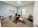 Well-lit home office with a world map and two different style chairs at 1412 Brentwood Dr, Kissimmee, FL 34746