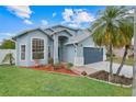 Inviting two-story home with mature landscaping, a blue exterior, and an attached two-car garage at 1517 Abberton Dr, Orlando, FL 32837