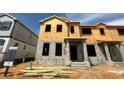 Unfinished two-story townhouse with visible framing and concrete block construction on a sunny day at 15363 Burgtheater Dr, Winter Garden, FL 34787