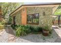 Exterior elevation showing stone facade, window, and lush landscaping at 1860 Ne 62Nd St, Ocala, FL 34479
