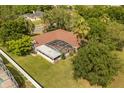 Aerial view of the property with a screened pool and a spacious yard surrounded by lush greenery at 200 Montego St, Kissimmee, FL 34743