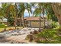 Charming single-story home with mature landscaping and a two-car garage nestled among palm trees at 200 Montego St, Kissimmee, FL 34743