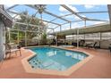 Inviting screened-in pool area featuring a pool, hot tub, barbecue, and outdoor seating for relaxation and entertainment at 200 Montego St, Kissimmee, FL 34743