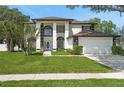 Beautiful two-story home boasts a lush green lawn and a charming white exterior with black accents at 2233 Blossomwood Dr, Oviedo, FL 32765