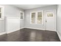 Bright living room with dark hardwood floors, fresh gray paint, and natural light from large windows at 2504 Yale Ave, Sanford, FL 32773