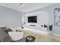 Modern living room with a large TV, sleek media console, plush sofa, and stylish decor at 2934 Title St, Kissimmee, FL 34746