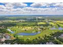 Scenic aerial view of the golf course and surrounding landscape with homes nearby at 3312 Cordgrass Pl, St Cloud, FL 34773