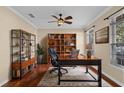 A charming home office featuring built in bookcases, rich wood floors, and a large window for ample natural light at 3331 Morelyn Crest Cir, Orlando, FL 32828