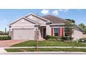 Inviting single-story home with red shutters, stone accents, and a meticulously maintained lawn at 3529 Yarian Dr, Haines City, FL 33844