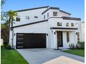 Modern two-story home featuring a dark garage door and minimalist landscaping at 3608 Dubsdread Cir, Orlando, FL 32804