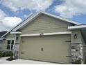 A tan two-car garage with stone accents at 4278 Sagefield Dr, St Cloud, FL 34773