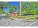 Corner lot featuring a charming single-story home with mature trees and lush landscaping at 430 S Dollins Ave, Orlando, FL 32805