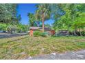 Charming single-story home on a sunny day surrounded by lush greenery and a palm tree at 430 S Dollins Ave, Orlando, FL 32805