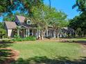 Charming home with rocking chair front porch and mature landscaping, nestled among mature trees at 6037 Lake Erie Rd, Groveland, FL 34736