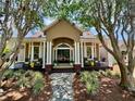 Charming home exterior featuring a welcoming porch with rocking chairs and beautiful landscaping at 6037 Lake Erie Rd, Groveland, FL 34736