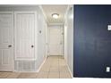 Hallway with tile flooring, neutral paint, and multiple doors for bedrooms and closets at 607 Brittany Ct, Casselberry, FL 32707