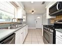 Functional kitchen features white cabinets, stainless steel appliances, and tile backsplash at 607 Brittany Ct, Casselberry, FL 32707