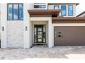 Up close view of front door and stacked stone exterior details on a two-story modern home at 7928 Jacks Club Dr, Kissimmee, FL 34747