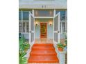 Inviting front entrance with vibrant steps, louvered doors, and vintage-style sconce lighting at 811 Laurel Ave, Orlando, FL 32803