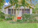 Home exterior featuring a screened porch with painted steps, surrounded by mature landscaping and palm trees at 811 Laurel Ave, Orlando, FL 32803