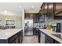 Modern kitchen with stainless steel appliances, tile backsplash, and a large island at 8549 Zoeller Hills Dr, Davenport, FL 33896