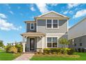 Charming two-story home featuring a quaint front porch and well-manicured lawn under a bright sky at 10209 Folly Beach Rd, Orlando, FL 32827