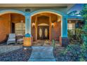 Inviting front entrance featuring double doors, brick columns, and a cozy seating area at 1130 Roxboro Rd, Longwood, FL 32750