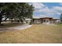 Spacious home with a wraparound porch and metal roof, complemented by mature trees and a private driveway at 11320 Montevista Rd, Clermont, FL 34711