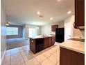 Open kitchen featuring an island with a sink, tile floors, and a seamless view into the living area at 133 Grove Branch Rd, Winter Haven, FL 33880