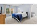 Cozy bedroom featuring plush carpet, ensuite bathroom and large windows with natural light at 14556 Unbridled Dr, Orlando, FL 32826